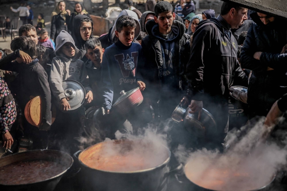 Displaced Palestinians gather to collect food in the northern Gaza Strip on Monday. One in six children under age 2 in northern Gaza suffers from acute malnutrition, a U.N. aid official said.