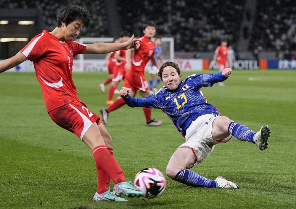 Japan defender Hikaru Kitagawa (right) makes a challenge in the first half of an Olympic women's soccer qualifier against North Korea at the National Stadium in Tokyo on Wednesday.
