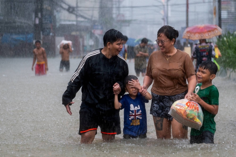 People wade through a flooded road after typhoon Doksuri in Bulacan province, Philippines, on July 29.