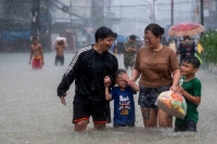 People wade through a flooded road after typhoon Doksuri in Bulacan province, Philippines, on July 29. | REUTERS
