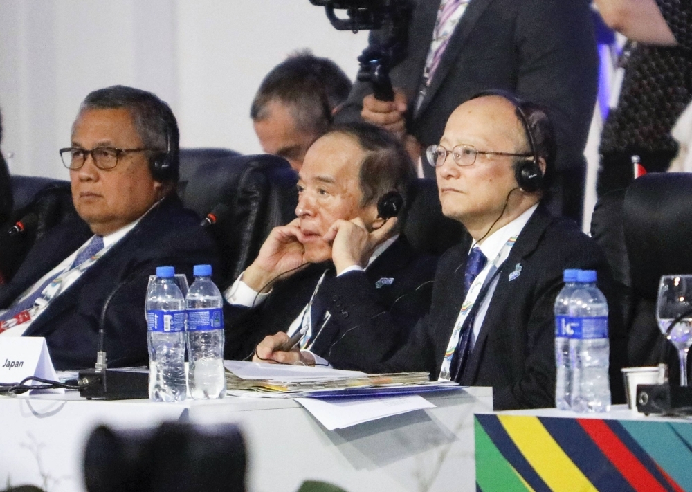 Masato Kanda, vice finance minister for international affairs (right), and Bank of Japan Gov. Kazuo Ueda (center) attend a G20 meeting of finance ministers and central bankers in Sao Paulo on Wednesday.