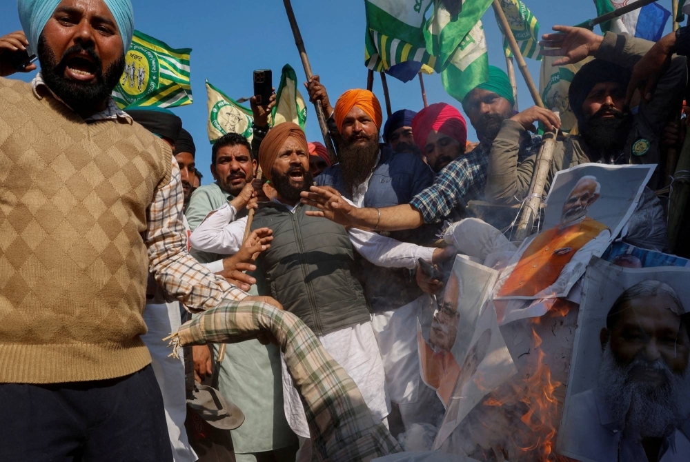 Farmers shout slogans as they burn an effigy of Prime Minister Narendra Modi and other ministers during a march toward New Delhi to push for better crop prices, at Shambhu Barrier, the border between Punjab and Haryana states, on Feb. 23.