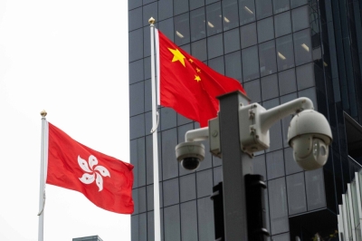 The flags of China and the Hong Kong Special Administrative Region (HKSAR) behind security cameras in Hong Kong on Wednesday. Hong Kong Chief Executive John Lee formally proposed the new security legislation on Jan. 30, with a one-month consultation period, to pass the city's own security law, including stepped-up efforts to ward against foreign interference.