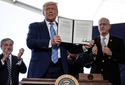Then-U.S. President Donald Trump holds up a presidential permit for energy development that he signed during a tour of an oil rig in Midland, Texas, in July 2020.