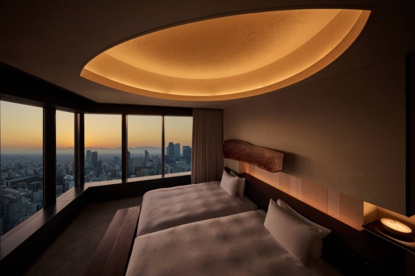The Iconic Suite's bedroom features recessed lighting and corner windows with sweeping views of the Nagoya metropolis.