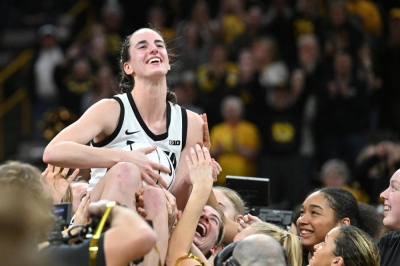 Hawkeyes guard Caitlin Clark celebrates with her teammates after breaking the NCAA's all-time scoring mark in Iowa City, Iowa, on Feb. 15.