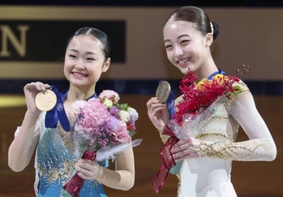 Mao Shimada (left) and Rena Uezono display their medals after the Japanese pair finished first and third, respectively, at the world junior figure skating championships.