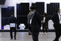 Solar panels on display at PV Expo in Tokyo on Wednesday. Japan's "transition bonds" will cover cutting-edge solar cells, as well as more controversial projects. | Bloomberg