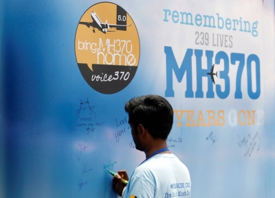 A man writes on a message board for passengers of missing Malaysia Airlines Flight MH370 during a remembrance event in Kuala Lumpur in March 2019.  