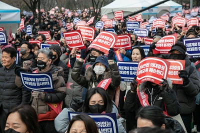 Doctors on Sunday lead thousands of protesters in a rally in Seoul demanding the government to scrap its plan to increase medical school enrollment.