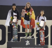 Second-place Kokona Hiraki (left) and third-place Mizuho Hasegawa (right) of Japan stand on the podium alongside Spain's Naia Laso, winner of the women's final at the Paris Olympic park skateboarding qualifier in Dubai on Sunday. | Kyodo