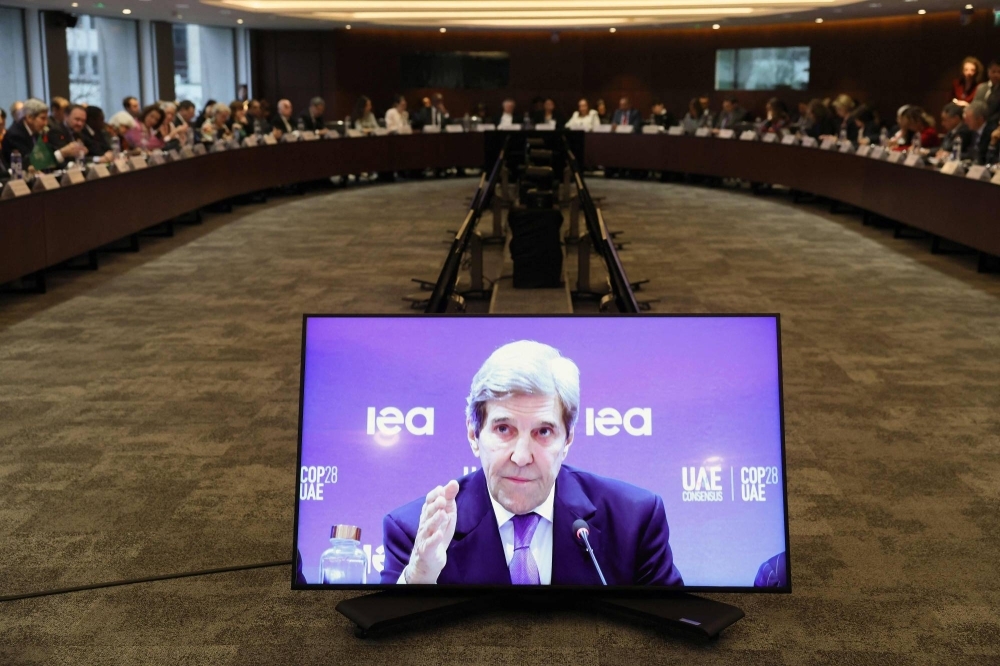 Kerry is seen on a screen as he speaks during a high-level round table on COP energy and climate commitments organized by the International Energy Agency at its headquarters in Paris on Feb. 20.