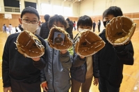 Elementary school pupils hold baseball gloves donated by Los Angeles Dodgers star Shohei Ohtani at Monzen East Elementary School in Wajima, Ishikawa Prefecture, on Monday. | Kyodo