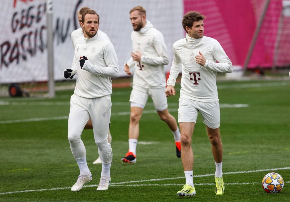 Bayern Munich forwards Harry Kane (left) and Thomas Mueller (right) attend a training session ahead of their team's last-16 second-leg UEFA Champions League soccer match against Lazio in Munich, on Monday.