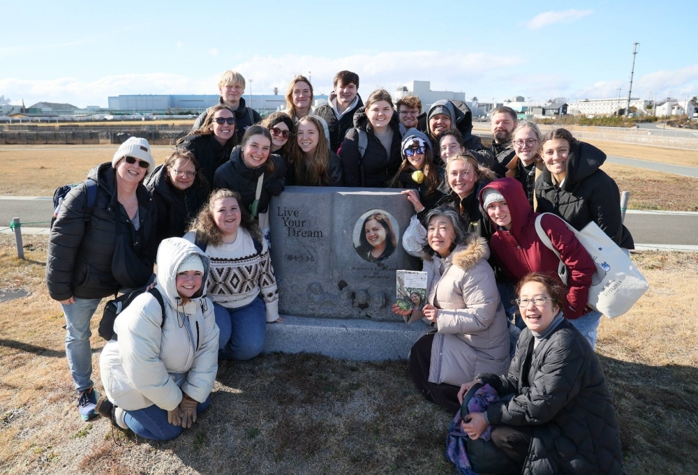 Randolph-Macon College students pose with a monument to Taylor Anderson in Ishinomaki, Miyagi Prefecture, on Jan. 23.