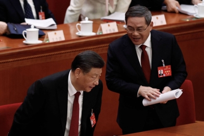 Chinese President Xi Jinping and Premier Li Qiang chat at the end of the opening session of the National People's Congress at the Great Hall of the People in Beijing on Tuesday.