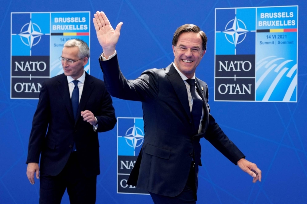 The Netherland's Prime Minister Mark Rutte waves as he walks past NATO Secretary-General Jens Stoltenberg during a summit at the alliance's headquarters in Brussels in June 2021.