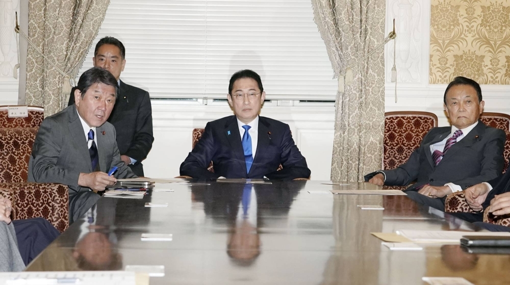 Liberal Democratic Party Secretary-General Toshimitsu Motegi (left), Kishida and the party's vice president, Taro Aso (right), meet in Tokyo on Feb. 19. Kishida finds himself further isolated from Motegi just as their party needs to agree on how to discipline its members over the slush fund scandal and prepare for by-elections.