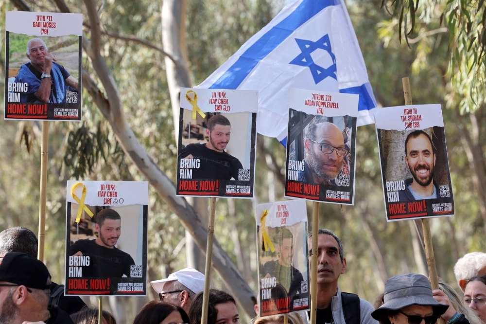 People hold portraits of Israeli hostages held in Gaza since the Oct. 7 attacks by Hamas militants, near the site of the Supernova music festival in southern Israel, in February.