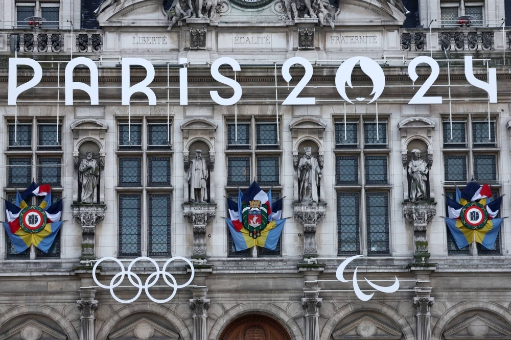The Paralympic logo (right) is seen alongside the Olympic rings on the facade of Paris city hall on Jan. 18.