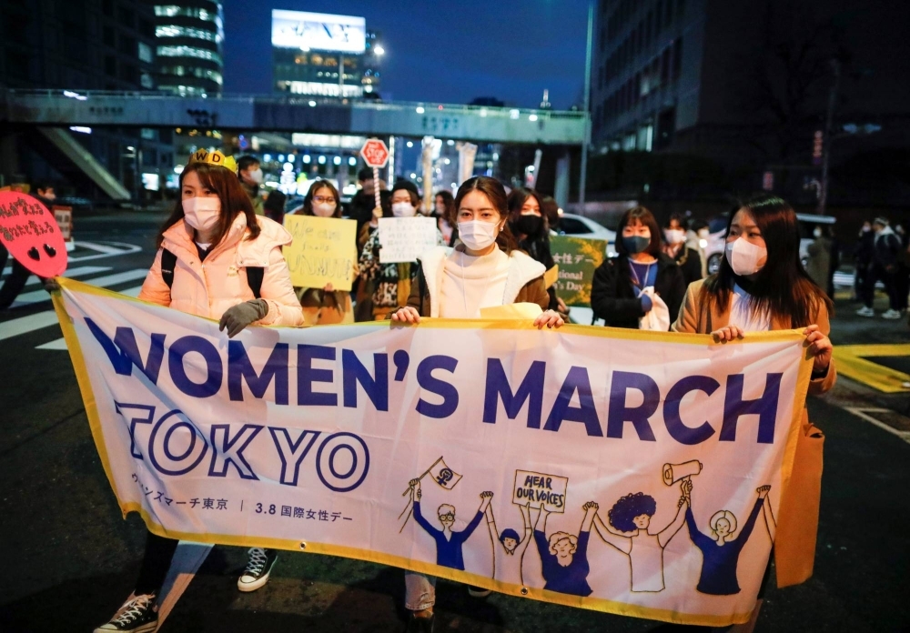 Demonstrators hold a banner as they take part in a march to call for gender equality and protest against gender discrimination as part of an International Women’s Day march in Tokyo in 2021.