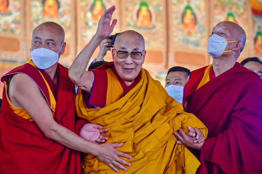 Tibetan spiritual leader Dalai Lama waves during his first day of a teaching session at the Kalachakra Ground in the village of Bodhgaya, in the Indian state of Bihar, in December 2022.