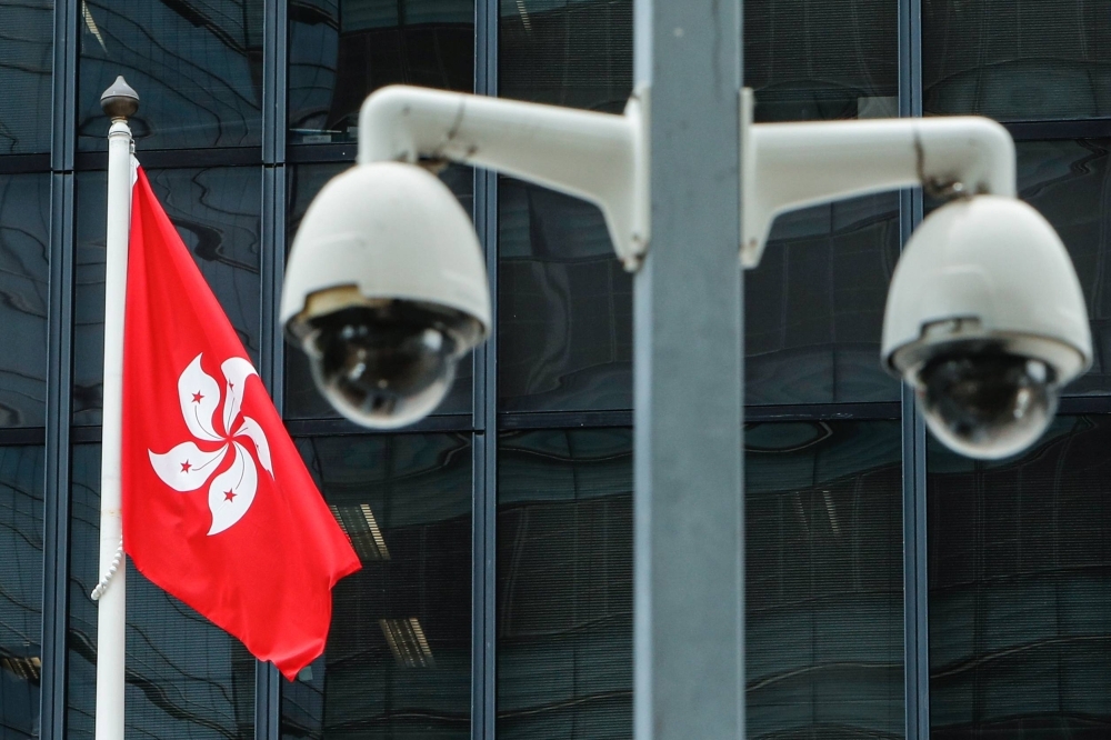 The Hong Kong flag and surveillance cameras outside the Central Government Offices in Hong Kong