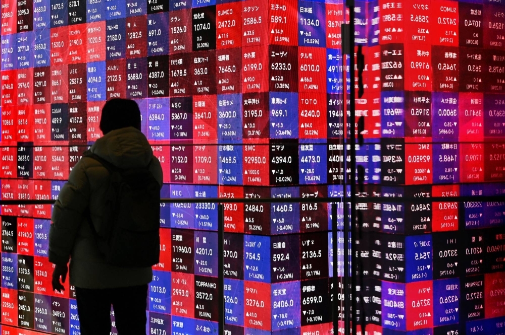 A man looks at electronic boards displaying stock prices of companies listed on the Tokyo Stock Exchange in Tokyo on Monday. The benchmark 225-issue Nikkei average has surged at an unexpected pace of about 20% this year 