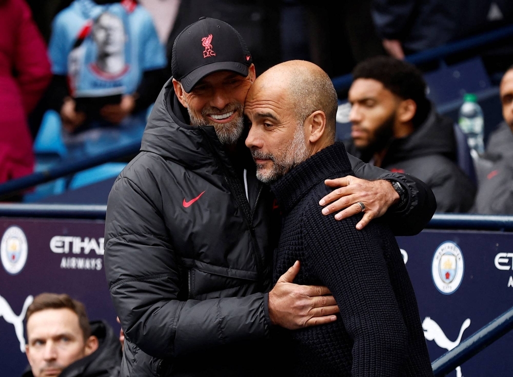 Liverpool manager Jurgen Klopp (left) embraces Manchester City manager Pep Guardiola before a match in Manchester, England, on April 1, 2023.