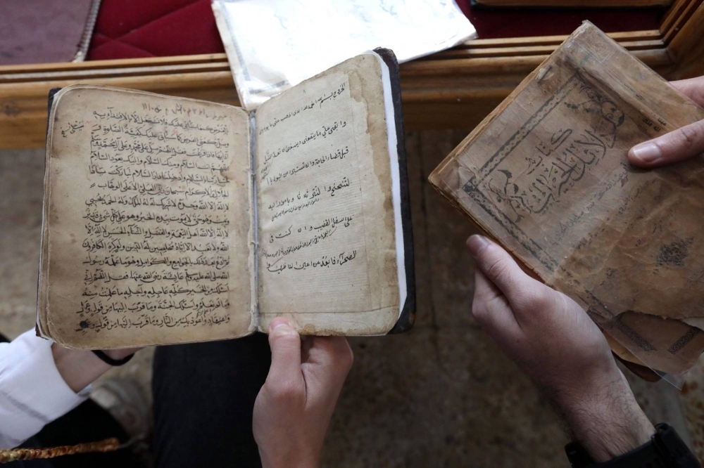 Members of the Kurdistan Centre for Arts and Culture, inspect old books before making digital copies, as part of an effort to digitize historic Kurdish volumes and manuscripts, in the northern Iraqi city of Dohuk on Feb. 13.