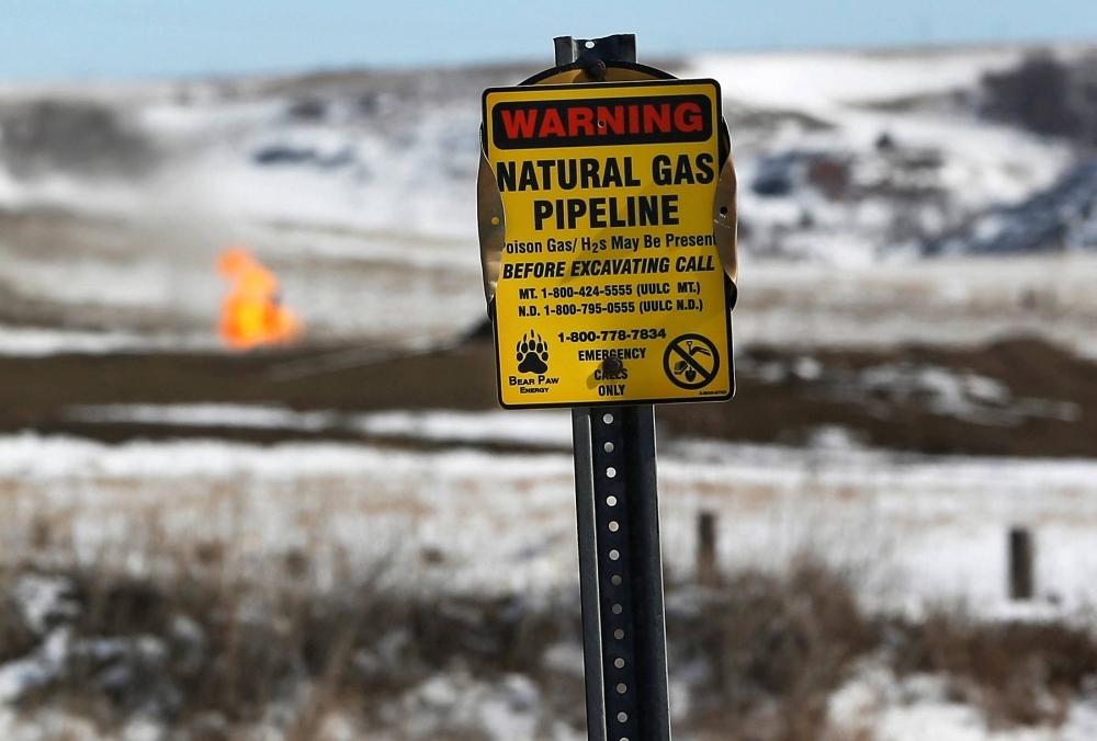A warning sign for a natural gas pipeline at an oil pump site outside of Williston, North Dakota, in March 2013