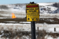 A warning sign for a natural gas pipeline at an oil pump site outside of Williston, North Dakota, in March 2013 | REUTERS
