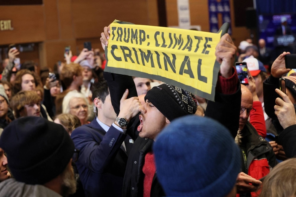 Climate protesters interrupt a campaign event for former U.S. President Donald Trump in Indianola, Iowa, on Jan. 14.