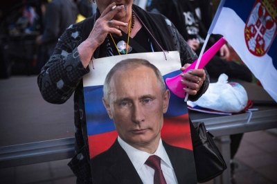 A woman holds a picture of Russian President Vladimir Putin during a rally organized by Serbian ultra nationalist organizations in Belgrade in 2022.
