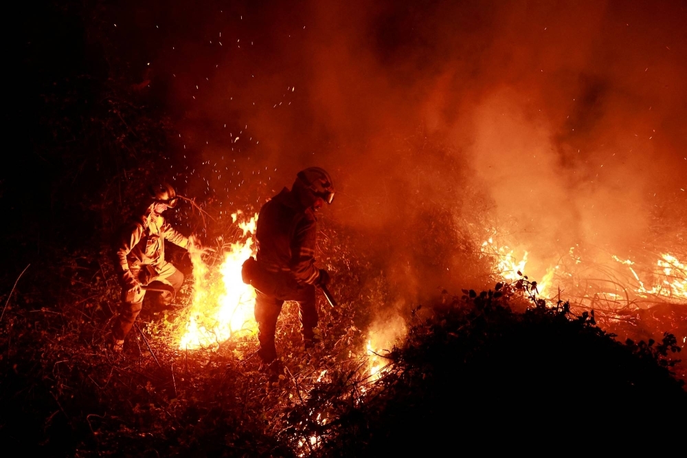 Firefighters tackle a blaze near the village of Piedrafita in northern Spain's Asturias region on March 31.