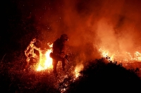 Firefighters tackle a blaze near the village of Piedrafita in northern Spain's Asturias region on March 31. | REUTERS
