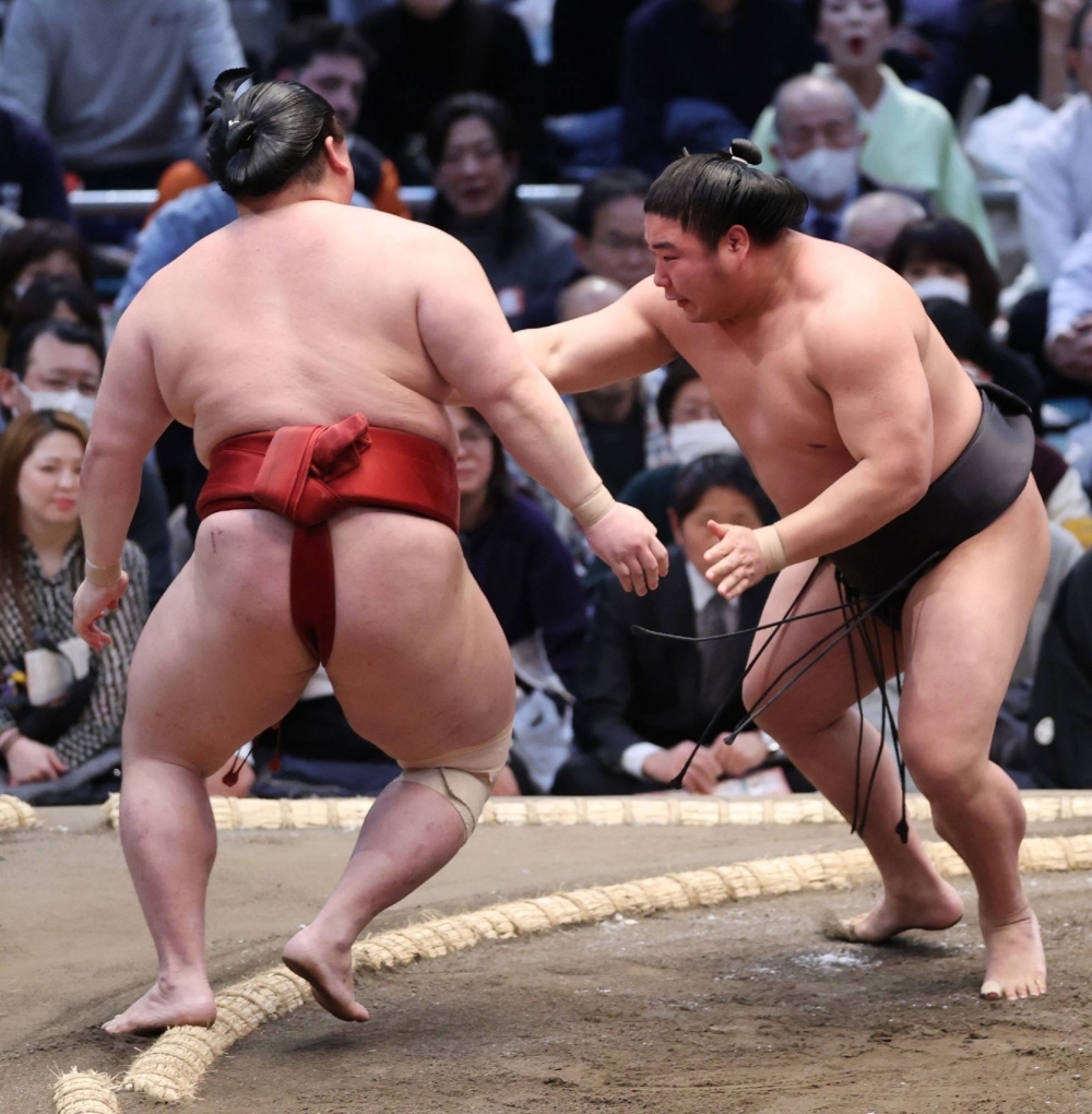 Wakamotoharu (right) defeats Takanosho on the third day of the Spring Grand Sumo Tournament at Edion Arena Osaka on Tuesday.