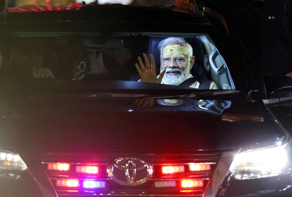 India's Prime Minister Narendra Modi waves to supporters from a car after offering prayers at the Kashi Vishwanath Hindu temple in Varanasi on Saturday.