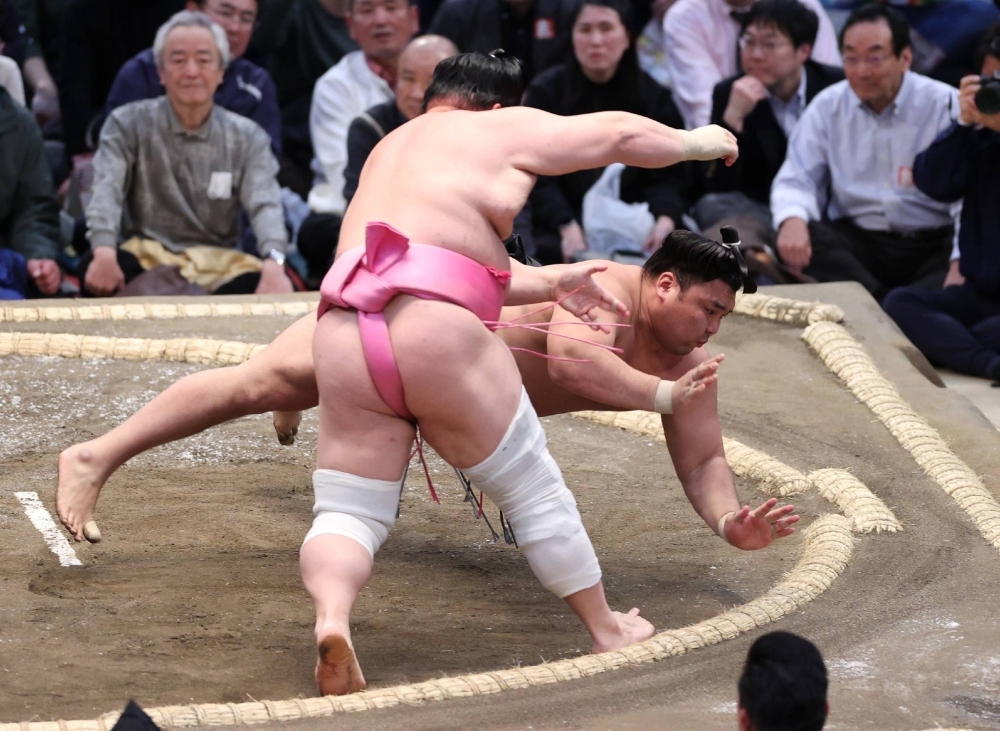 Kirishima (behind) gets thrown down against Ura on Tuesday. The newly promoted ozeki's 0-3 start in Osaka has been one of the big disappointments of the tournament so far. 