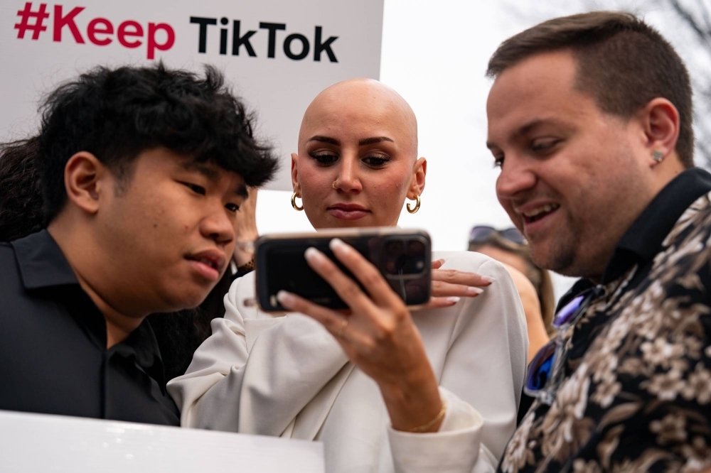 Supporters of TikTok watch a feed of the U.S. House vote as they gather outside the Capitol in Washington on Wednesday. 