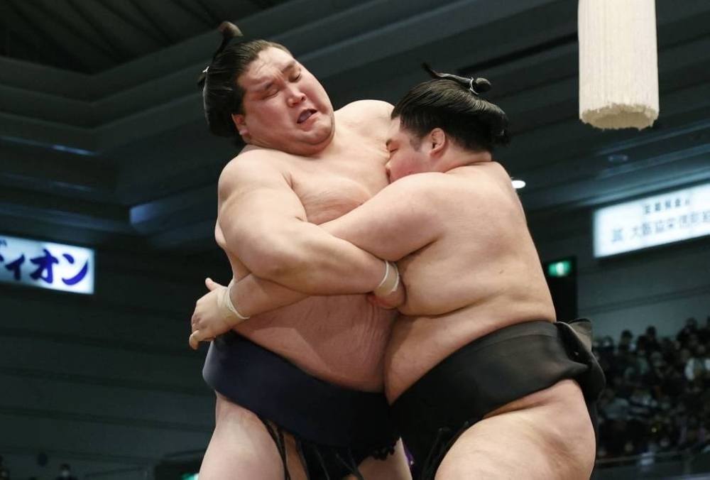 Terunofuji (left) was easily forced out by No. 2 maegashira Meisei at the Spring Grand Sumo Tournament in Osaka on Wednesday.