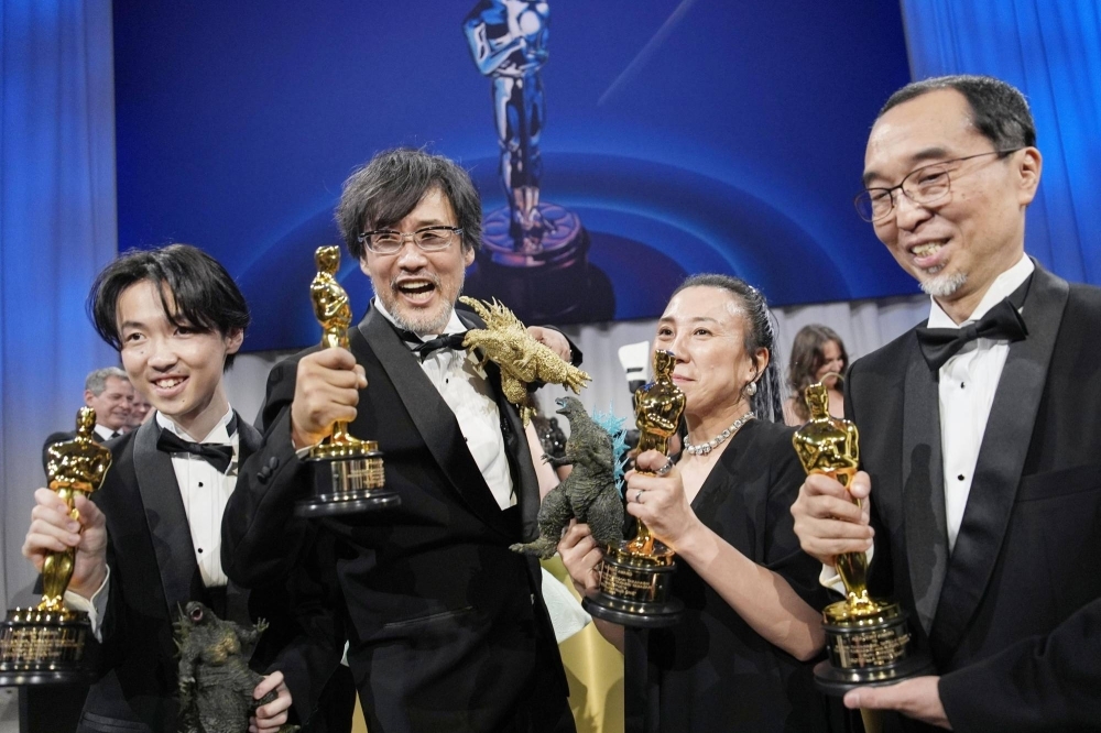 "Godzilla Minus One" director Takashi Yamazaki (second from left) celebrates with members of his visual effects team after they won the Oscar for best visual effects. 