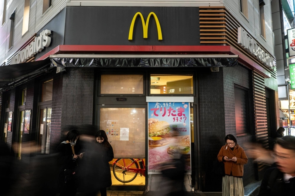 People stand in front of a temporarily closed McDonald's in Tokyo's Shimbashi district on Friday as the chain experienced widespread tech issues. 