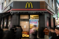 People stand in front of a temporarily closed McDonald's in Tokyo's Shimbashi district on Friday as the chain experienced widespread tech issues.  | AFP-JIJI