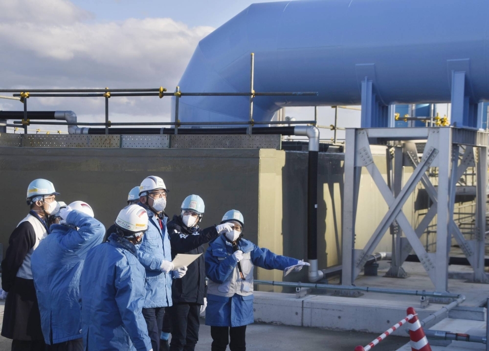 Officials including Rafael Grossi, director-general of the International Atomic Energy Agency, inspect equipment used to release treated radioactive water into the sea at the Fukushima No. 1 nuclear power plant in Fukushima Prefecture on Wednesday.
