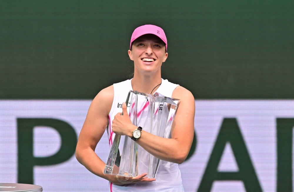Poland's Iga Swiatek holds the championship trophy after defeating Greece's Maria Sakkari during the ATP-WTA Indian Wells Masters women's final in Indian Wells, California, on Sunday.
