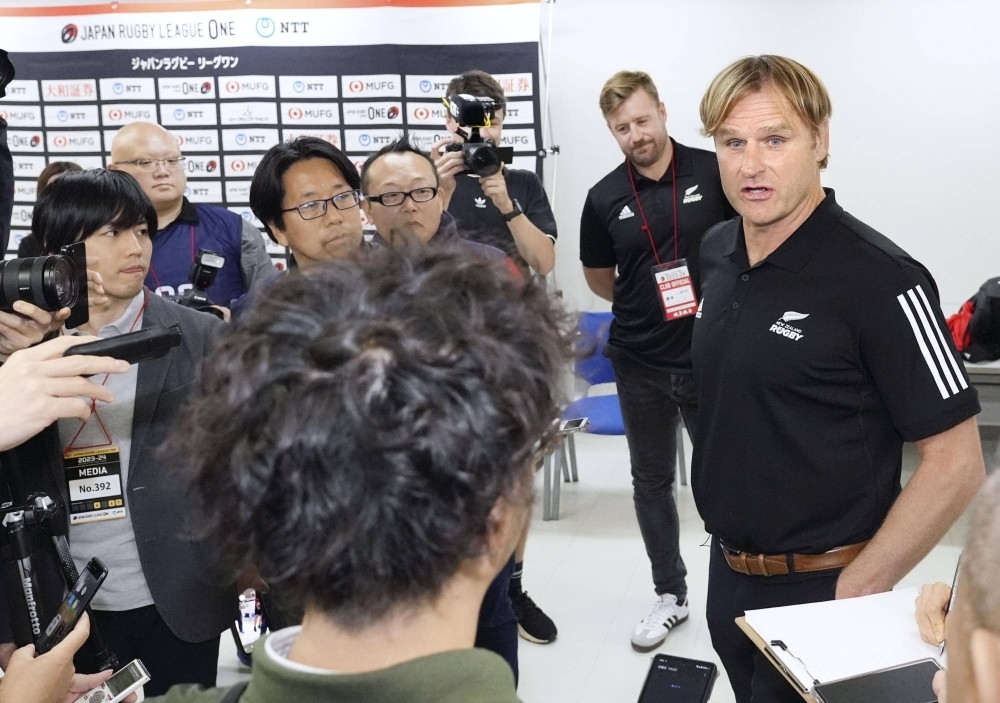 Scott Robertson (far right), head coach of New Zealand's national rugby team, speaks to reporters at Tokyo's Prince Chichibu Memorial Rugby Ground on Sunday.