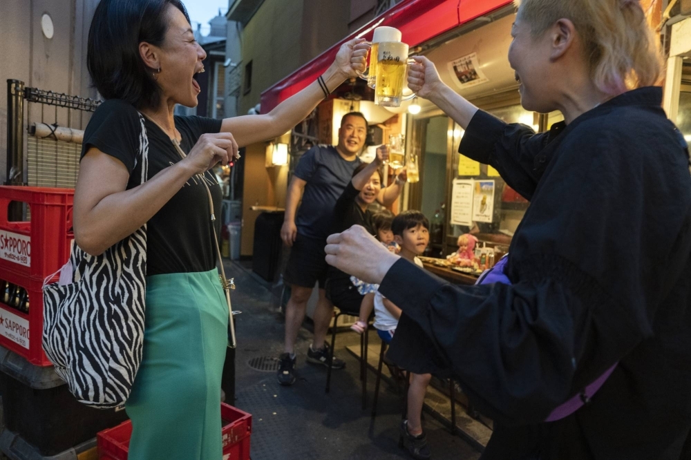 Customers make a toast at an eatery in Tokyo. Many view Japan’s economy as being on the rise, and that of regional powerhouse China as declining. But how accurate is this narrative?
