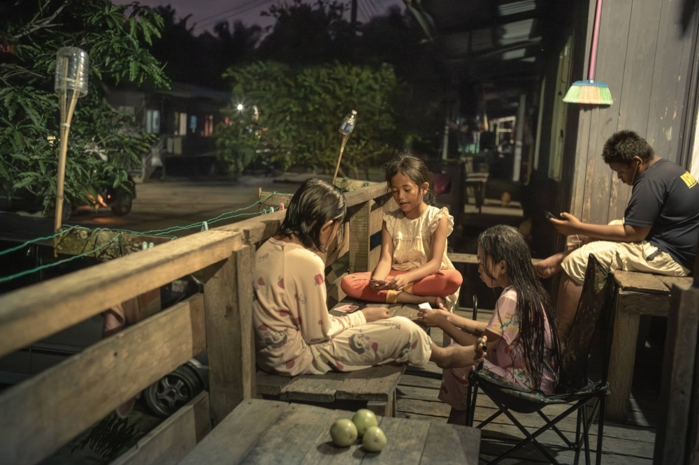 Children of palm plantation workers play cards at their house in Labuk, Malaysia on Feb. 14. Nearly 4.5 million people in Malaysia and Indonesia are employed in the industry. 