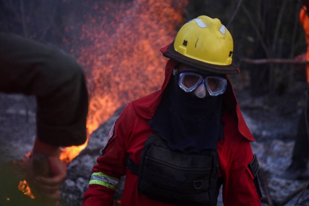 A firefighter tackles a fire in a sugar field in San Buenaventura, Bolivia, in November 2023.